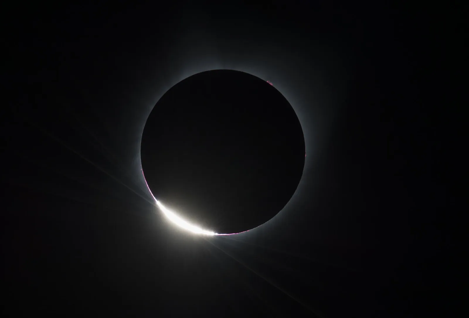 The diamond ring effect at the start of totality: a thin bright edge of the Sun beside the dark Moon and the white corona